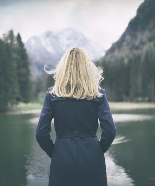 Blonde,Woman,Standing,Backwards,And,Watching,Magic,Lake,In,Mountainous